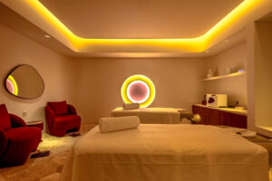 Warmly lit Mello Spa treatment room with two massage tables and relaxing ambient lighting in Seminyak