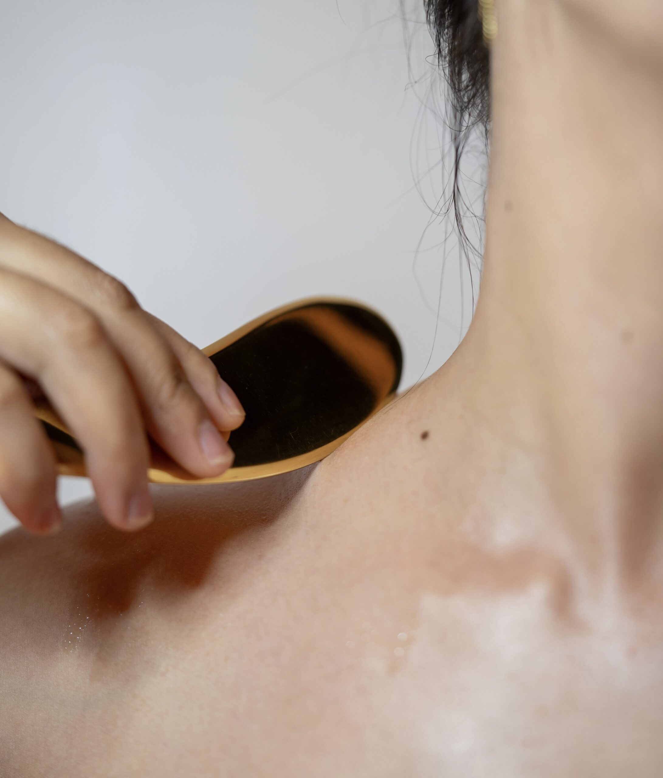 Copper Gua Sha tool and essential oils used to enhance massage experience at Mello Spa